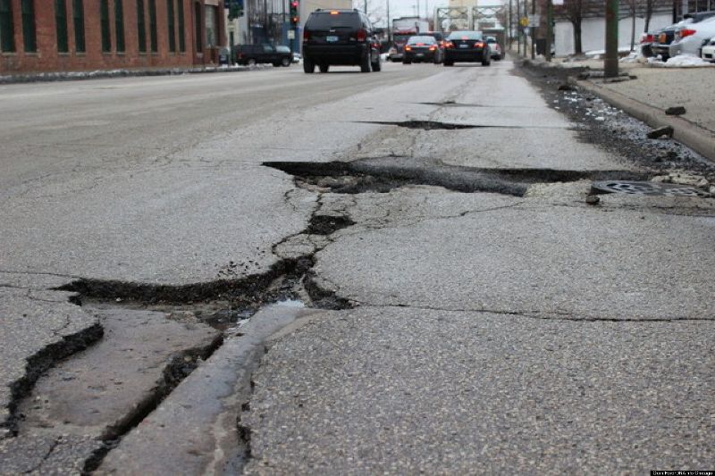 cars on cracked road with holes