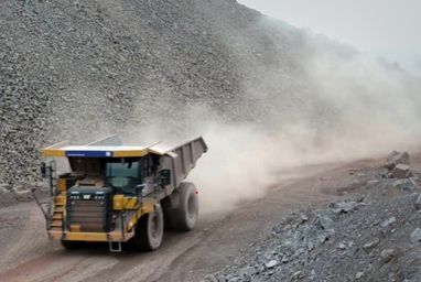 yellow truck driving on dusty road